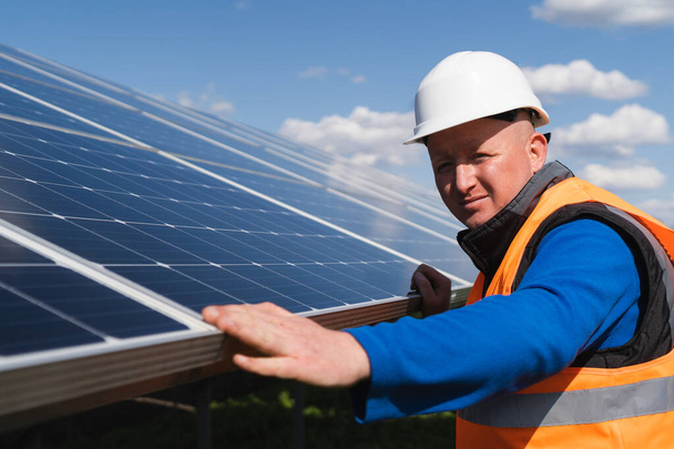 Werknemer zonne-energie inspecteert fotovoltaïsche panelen op schade - Foto, afbeelding