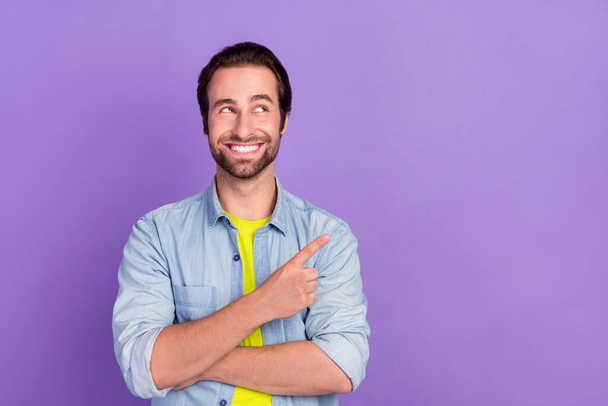 Photo of dreamy smiling student guy looking copyspace advertise product isolated on purple color background - Φωτογραφία, εικόνα