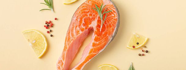 Rauwe verse vis zalm biefstuk bovenaanzicht op beige pastel achtergrond van boven - Foto, afbeelding