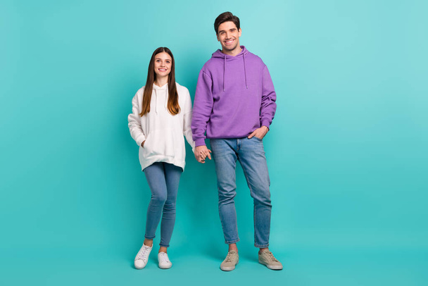 Full size photo of lovely pretty students in relationship go on date wear casual style hoodie isolated on blue color background - Fotó, kép