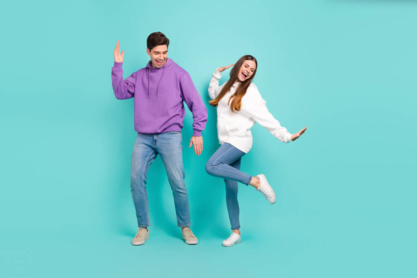 Full size photo of casual wear students girlfriend and boyfriend dancing in club isolated on blue color background - Foto, afbeelding
