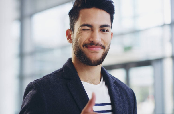 Ive got this. Cropped shot of a young businessman showing winking and showing thumbs up while walking through a modern office. - Photo, image