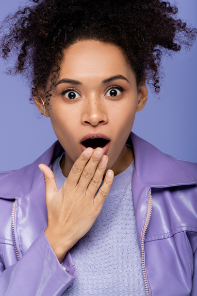 mujer afroamericana conmocionada con la boca abierta aislada en púrpura  - Foto, imagen
