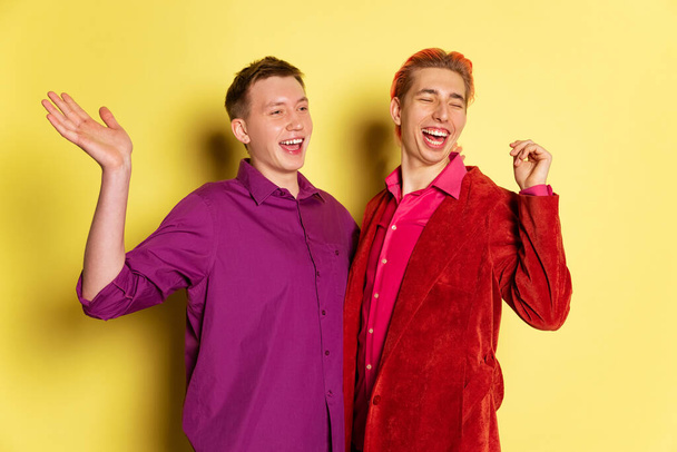 Portrait of young men, couple posing isolated on yellow background. Valentines day celebration. Concept of emotions, love, relations, romantic - Foto, immagini