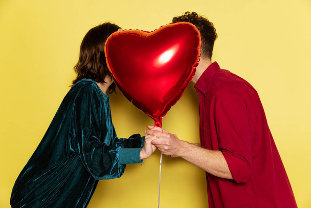 Happy couple, man and woman holding balloons shaped hearts. Valentines day celebration. Concept of emotions, love, relations, romantic holidays. - Fotoğraf, Görsel