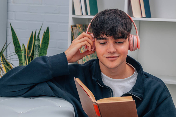 tiener jongen thuis lezen luisteren naar muziek - Foto, afbeelding