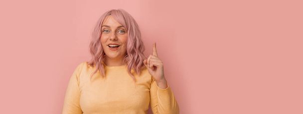 Όμορφη νεαρή γυναίκα με ροζ σγουρά βαφή μαλλιών ποζάροντας αντίγραφο κενό χώρο απομονωμένο σε φωτεινό ροζ φόντο χρώμα - Φωτογραφία, εικόνα