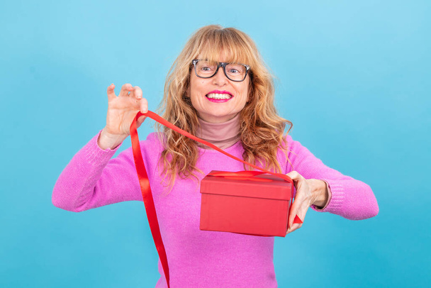 mujer adulta abriendo caja de regalo aislado en fondo - Foto, imagen