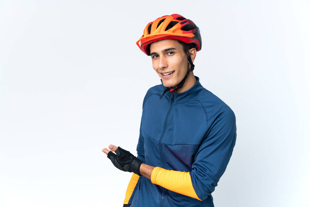 Молодой велосипедист изолирован на заднем плане протягивая руки в сторону для приглашения приехать - Фото, изображение