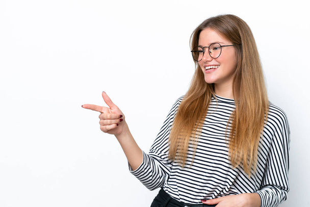 Jonge blanke vrouw geïsoleerd op witte achtergrond wijzend vinger naar de zijkant en presenteren een product - Foto, afbeelding