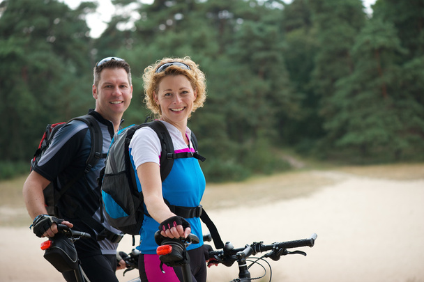 Cheerful couple relaxing outdoors with bikes - Photo, Image