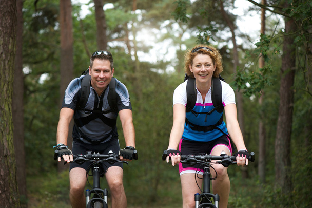 man en vrouw fietser glimlachend buitenshuis  - Foto, afbeelding