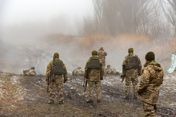 防弾ベストとヘルメットの兵士は霧の日に機関銃で標的練習に. - 写真・画像