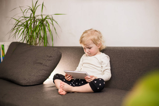 Egy kisfiú rajzfilmeket néz egy tableten. - Igen. Gyermekek és modern technológiák. - Fotó, kép