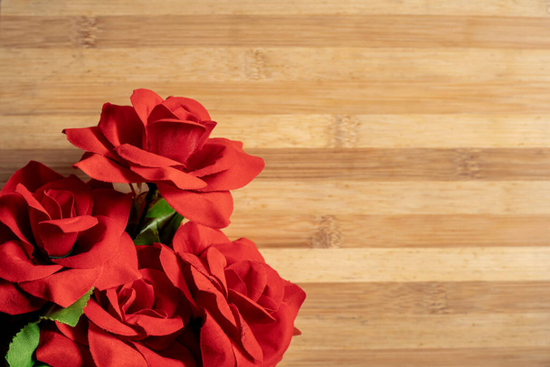 A bouquet of red roses on a wooden table - Foto, imagen