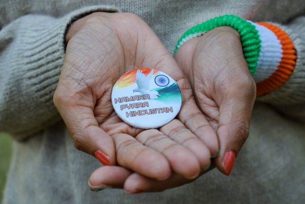 Weibchen mit indischem Abzeichen mit der Aufschrift "humara pyara hindustan", was "Unser schönes Indien" bedeutet. Person, die indischen Unabhängigkeitstag oder Tag der Republik wünscht - Foto, Bild