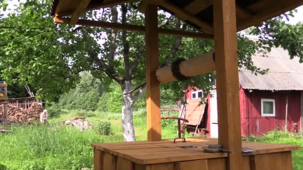 Drewniany dom dobrze i człowiek pracownik farmy rąbać drewno - Materiał filmowy, wideo