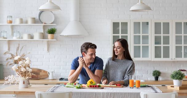 Happy couple in the kitchen standing at the table preparing a healthy and healthy breakfast. Vegetarian family. - Foto, Imagem