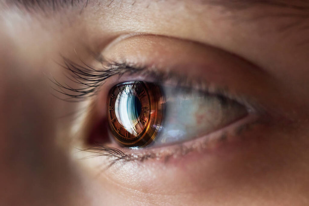 Манипуляция глазным яблоком с сфотографированным макросом и изображением часов - Фото, изображение