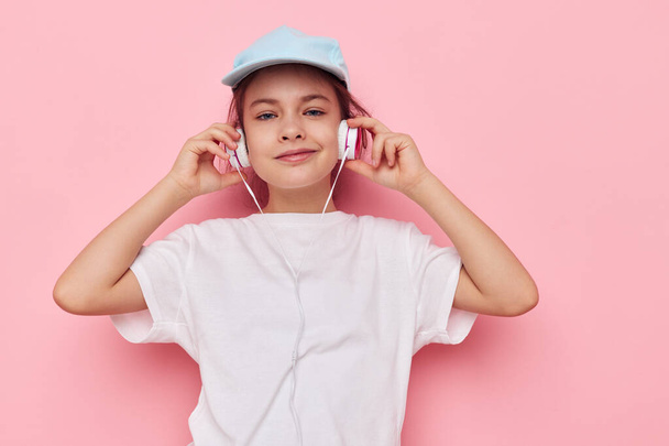 cute girl headphones in a white t-shirt and a cap Lifestyle unaltered - Zdjęcie, obraz