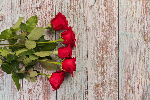 Katsaus punaisiin ruusuihin maalaispuupöydällä - Valokuva, kuva