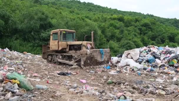 Vecchio trattore alla discarica. Il problema dei rifiuti di plastica nell'ecologia mondiale.  - Filmati, video