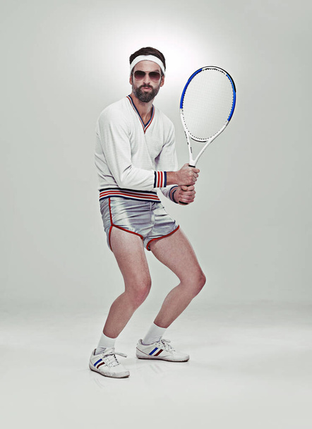 Ready for your serve. Portrait of a young retro tennis player in the studio. - Foto, Imagen