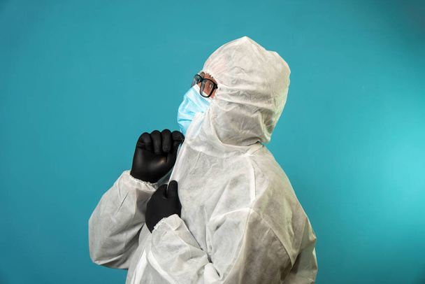 muotokuva lääkäri covid suojapuku sinisellä pohjalla studiossa - Valokuva, kuva