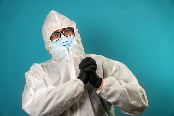 portrait of doctor in covid protection suit on blue background in studio - Photo, Image