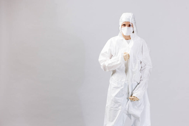 Tired doctor wearing mask and gloves at the hospital in coronavirus times, checking his smartphone. - 写真・画像