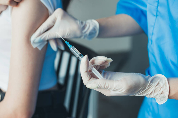 Szoros portré orvosok kezét alkalmazó pamut pad a betegek karján. Vírusvédelem. Orvos kéz. Coronavirus vakcinázás. - Fotó, kép