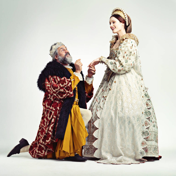 Join me on the throne. Studio shot of a king proposing to a royal lady. - Foto, imagen