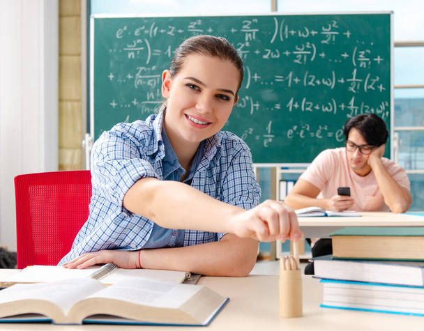 Los jóvenes estudiantes que toman el examen de matemáticas en el aula - Foto, imagen