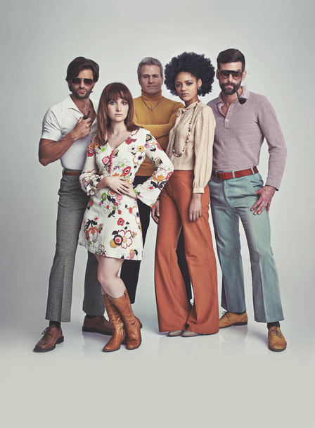 Semmi sem fogható a 70-es évekhez. Egy stúdiókép egy csapat emberről, akik együtt állnak, miközben retro 70-es éveikben öltözködnek.. - Fotó, kép