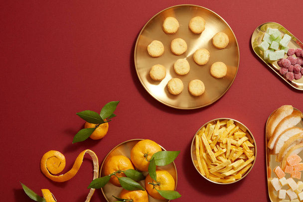 Tet vakantie met mandarijn sinaasappel snoep jam, gebakken aardappel, bloem en koekje in gouden schotel, fotografie Tet vakantie inhoud - Foto, afbeelding