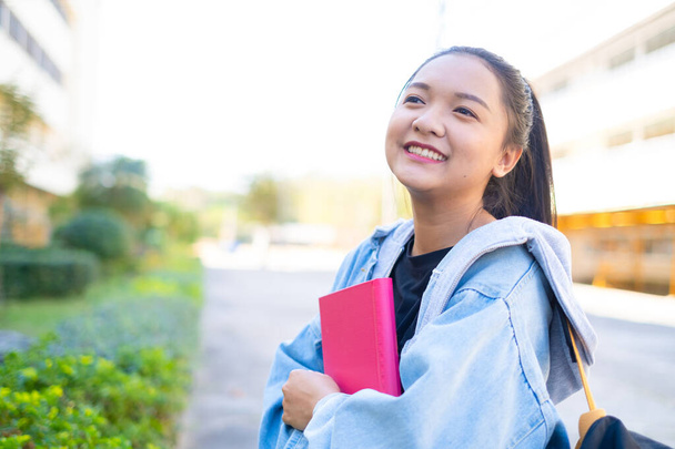 Happy student girl hold book and backpack at school, Asian girl. - Photo, Image
