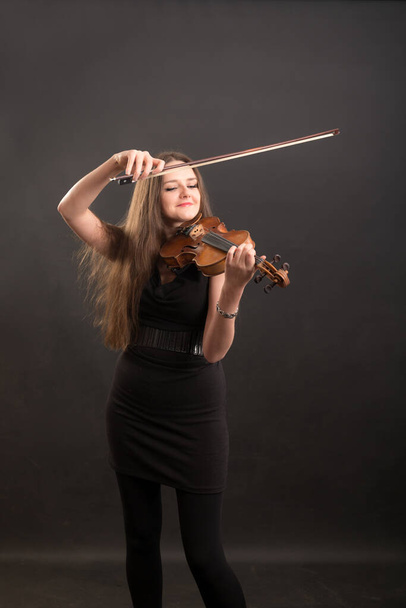 studio portrait of a violinist in a black dress - Фото, зображення