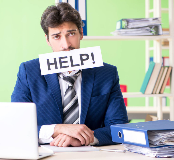 Businessman unhappy with excessive work sitting in the office - Photo, Image