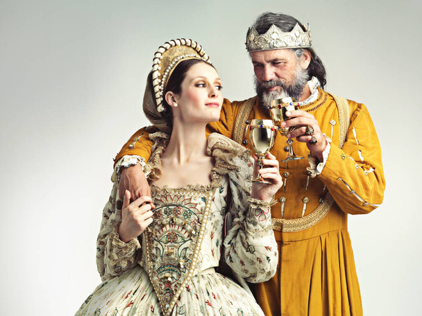 Het is goed om koninklijk te zijn. Studio shot van een koning en koningin drinken uit bekers. - Foto, afbeelding