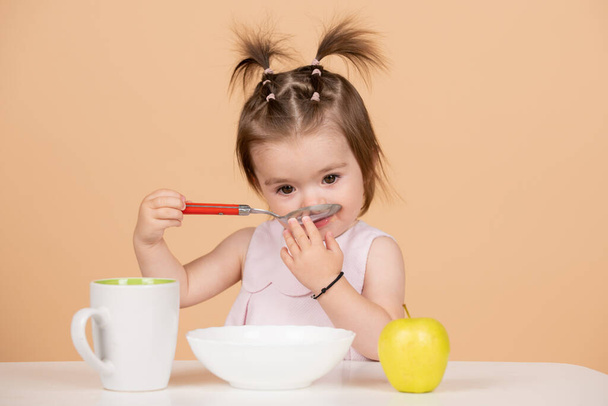 Baby child eating food. Kid girl eating healthy food. - Foto, Imagem