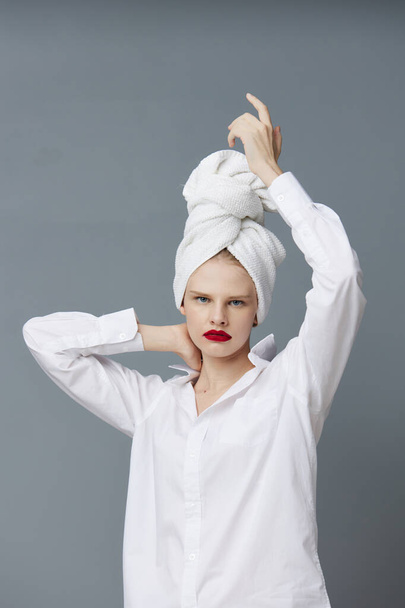 fashionable woman with a towel on his head in a white shirt isolated background - Fotó, kép