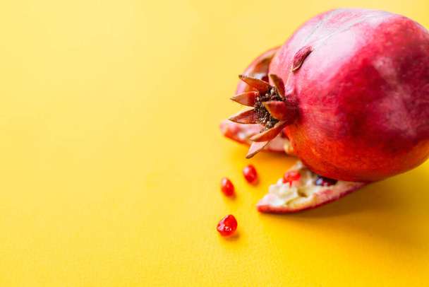 Fresh ripe pomegranate over yellow background close-up - Foto, Imagen