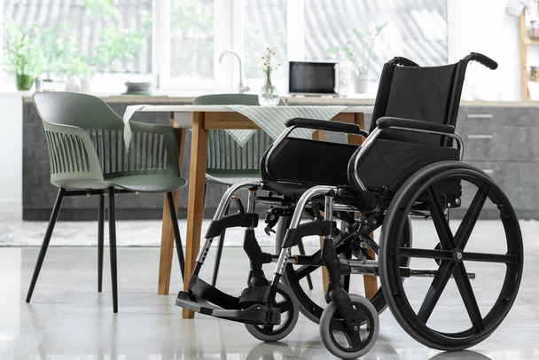 Пустое инвалидное кресло на современной кухне - Фото, изображение