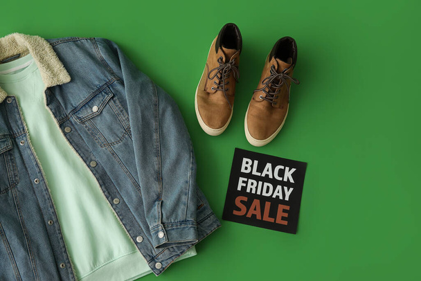 Paper with text BLACK FRIDAY SALE, male clothes and sneakers on green background - Foto, Imagem