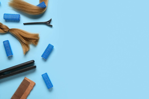 Long brunette hair with curlers and combs on blue background - Photo, Image