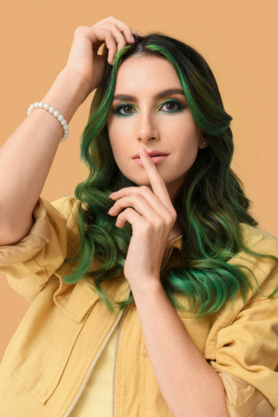 Belle jeune femme avec des cheveux verts inhabituels sur fond de couleur - Photo, image