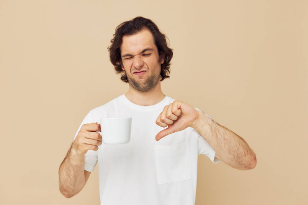 handsome man with a white mug in his hands emotions posing Lifestyle unaltered - Foto, imagen