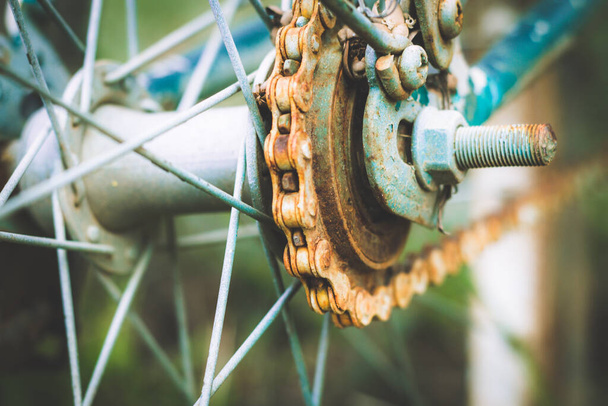 Κοντινό πλάνο της παλιάς σκουριασμένης αλυσίδας από το ποδήλατο στη φύση φόντο, θέα λεπτομέρεια του ποδηλάτου του τροχού με παλιά αλυσίδα, γρανάζι, βρώμικη αλυσίδα (Vintage τόνο)  - Φωτογραφία, εικόνα