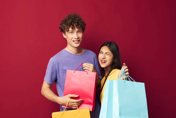 teenagers in colorful T-shirts with bags Shopping isolated background unaltered - Фото, изображение