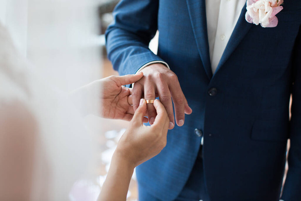The bride puts a ring on the brides finger during the wedding ceremony. - 写真・画像